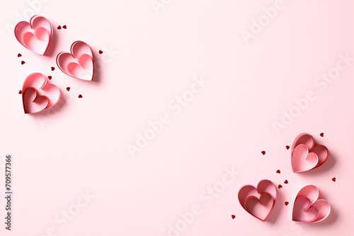 Valentine's day hearts with confetti on pastel pink background.