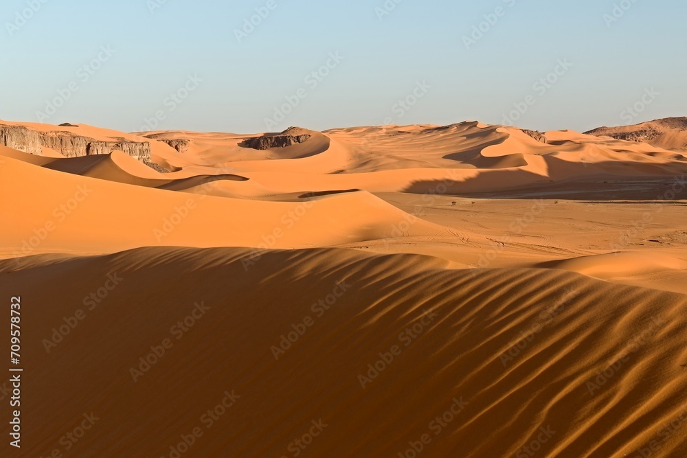View on Dunes of Moul n Aga, Tadrart Rouge rocky mountain range in Tassili n Ajjer National Park. Sahara desert, Algeria, Africa.