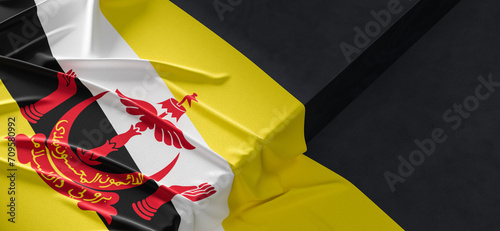 Flag of Brunei. Fabric textured Brunei flag isolated on dark background. 3D illustration photo