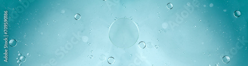 Oil and water, transparent blue bubbles, soap suds with water blue background. Space for copy.