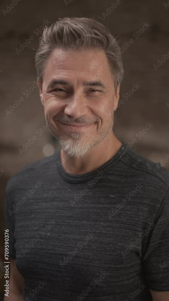 Portrait of happy middle aged older man in a dark industrial room, smiling. Portrait of happy middle aged older man in a dark industrial room, smiling.
