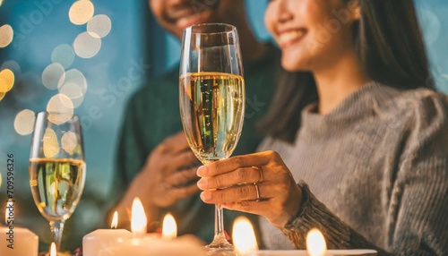 romantic candlelight dinner table setup for couple with beautiful light as background man woman hold glass of champaign concept for valentine s day and date photo