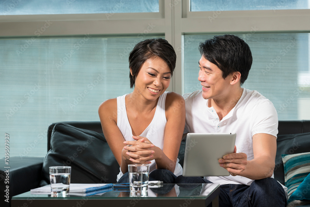 Fototapeta premium Young Chinese couple using a digital tablet