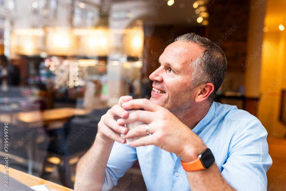 Happy businessman holding coffee cup at cafe Happy businessman holding coffee cup at cafe