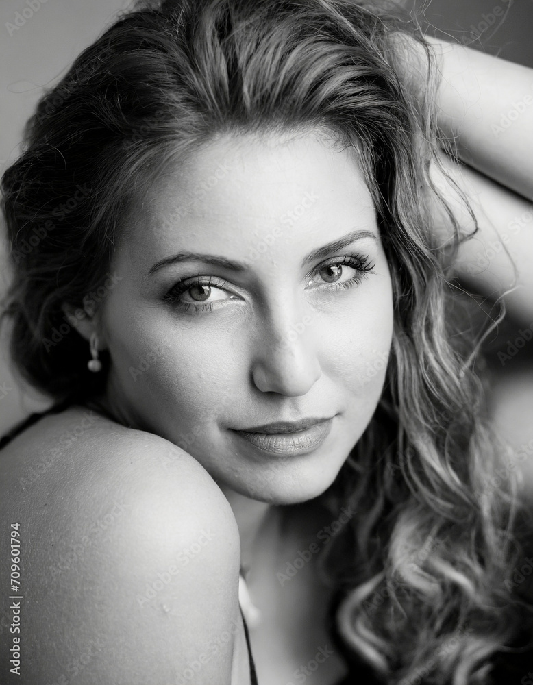 Naklejka premium Black and white closeup of a beautiful young woman looking straight ahead