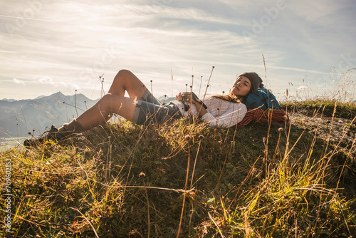 Young woman resting on mountain in Tannheimer Tal, Tyrol, Austria photo