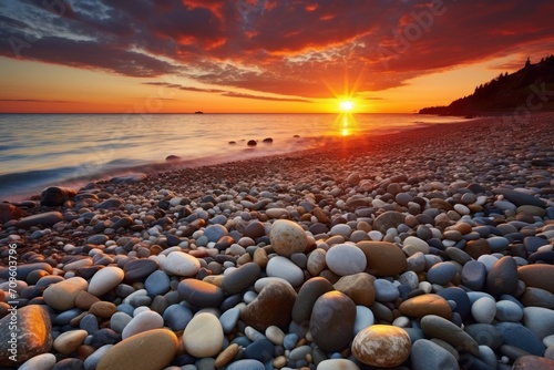  the sun is setting over the ocean with rocks in the foreground and a body of water in the background.