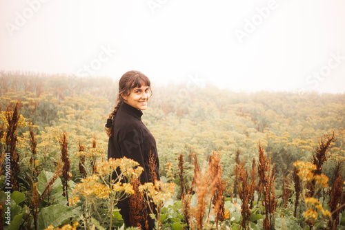 Smiling young woman standing in bush photo