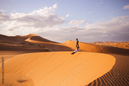 Man and woman on sand dune at Sahara desert in Morocco, Africa photo