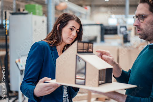 Architects examining model house standing in workshop photo