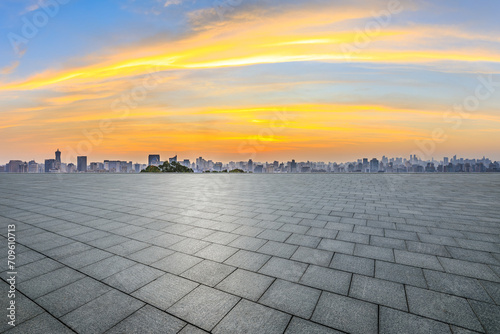 Empty square floor and city skyline at sunrise