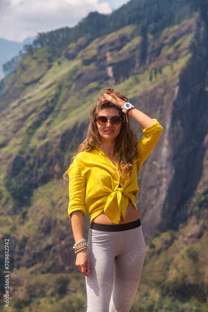 Portrait of pretty woman in sunglasses enjoying at tropical journey, looking at camera. Lovely adult lady posing at Sri Lanka Adam's peak mountain, landmark nature, Ella, Sri Lanka. Copy ad text space