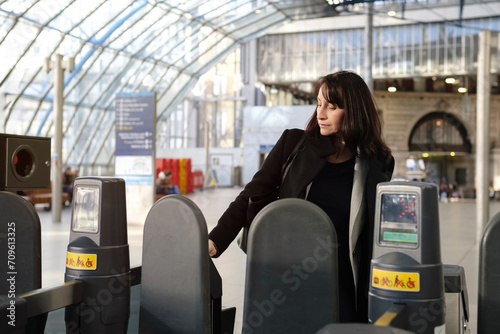 Mature woman scanning ticket at railway station photo