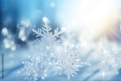  a group of snowflakes sitting on top of a snow covered ground with a blue sky in the background.