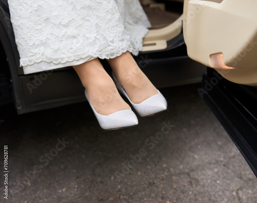 Bride wearing white wedding dress and shoes. white shoes on the feet of the bride.