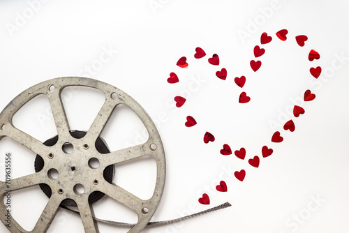Love story movie concept. Film reels with red hearts, top view