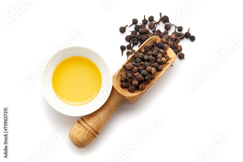Top view of Dry organic Sheetal Chini (Piper cubeba) seeds, in a wooden scoop along with its essential oil. photo