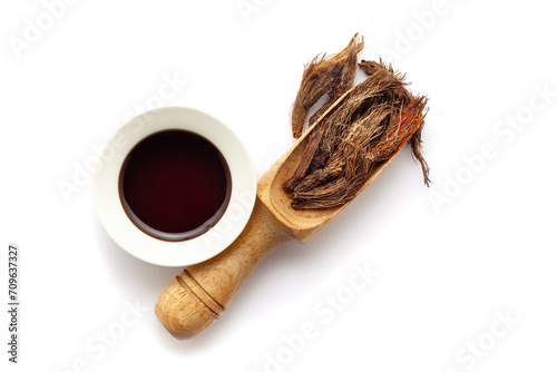 Top view of Dry organic Jatamansi (Nardostachys jatamansi) roots, in a wooden scoop along with its essential oil. photo