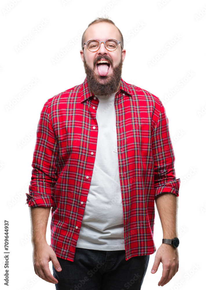 Young caucasian hipster man wearing glasses over isolated background sticking tongue out happy with funny expression. Emotion concept. Young caucasian hipster man wearing glasses over isolated background sticking tongue out happy with funny expression. Emotion concept.