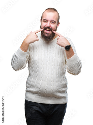 Young caucasian hipster man wearing winter sweater over isolated background smiling confident showing and pointing with fingers teeth and mouth. Health concept.