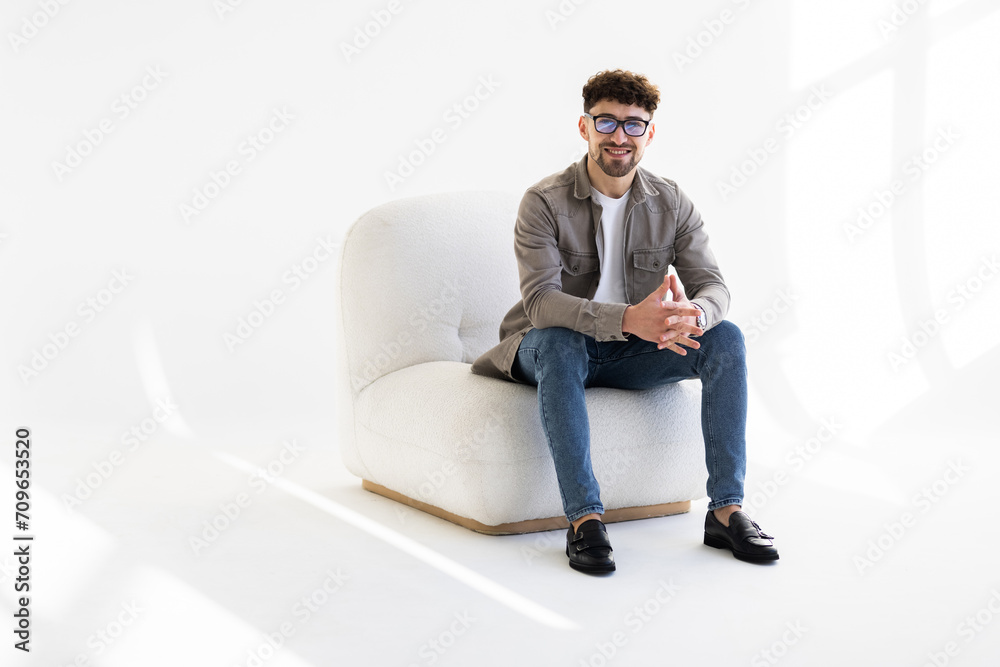 Portrait of attractive man sitting in armchair and looking at camera isolated over white background Portrait of attractive man sitting in armchair and looking at camera isolated over white background