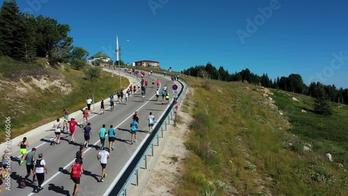 Aerial view of people on the move in a mountain landscape, Runners climbing the mountain road