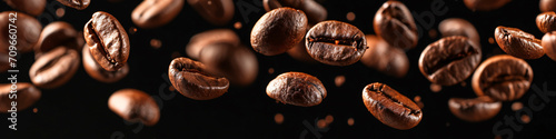 a falling coffee bean banner, roasted coffee bean on the air isolated on a black background, International Coffee Day concept