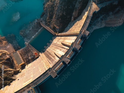 Top view of a massive dam structure with a reservoir in the mountains during clear weather photo