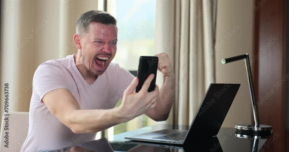 Happy man looking at phone screen and celebrating online victory. Emotions of financial monetary success and successful business contract
