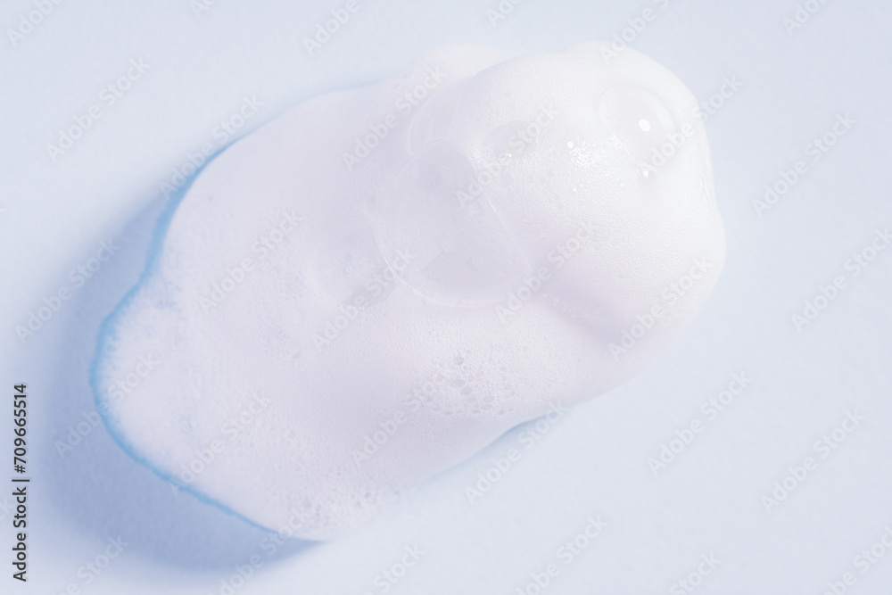 Foam texture on blue background. Soap, shampoo, mousse, shower gel foam, soap suds. Drop of bath foam. Foam texture on blue background. Soap, shampoo, mousse, shower gel foam, soap suds. Drop of bath foam.