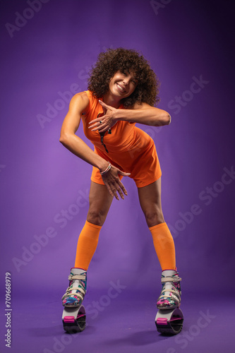 Beautiful sporty woman with curly hair wearing kangaroo jumper on studio background