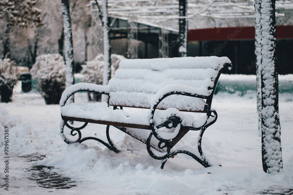 Snow covered bench in the park
