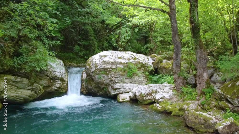 Surrounded by the vibrant hues of green forest trees and lush greenery, the river dances beneath the sun's magical glow, showcasing a waterfall in its enchanting embrace. Surrounded by the vibrant hues of green forest trees and lush greenery, the river dances beneath the sun's magical glow, showcasing a waterfall in its enchanting embrace.