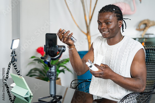 Animated black man reviews skincare products during a video shoot with a professional lighting and camera setup photo