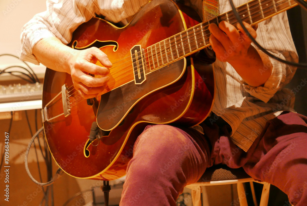 Obraz premium アコースティックギターを演奏する人 ライブ 男性 クローズアップ ギター 手元