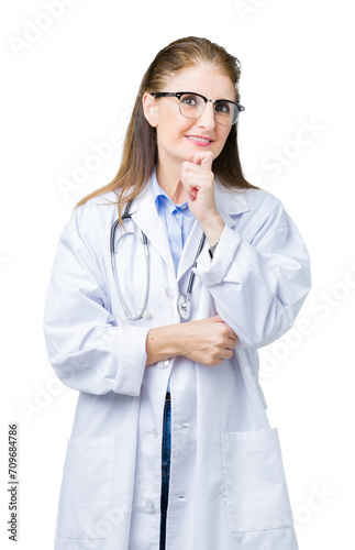 Middle age mature doctor woman wearing medical coat over isolated background looking confident at the camera with smile with crossed arms and hand raised on chin. Thinking positive.