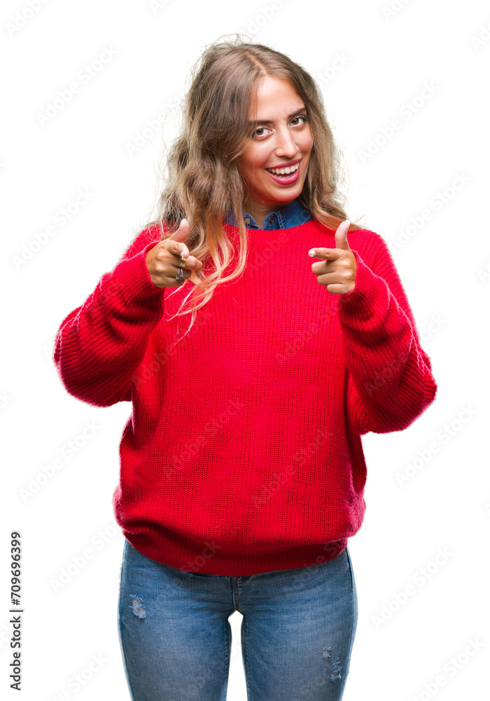 Beautiful young blonde woman wearing winter sweater over isolated background pointing fingers to camera with happy and funny face. Good energy and vibes.