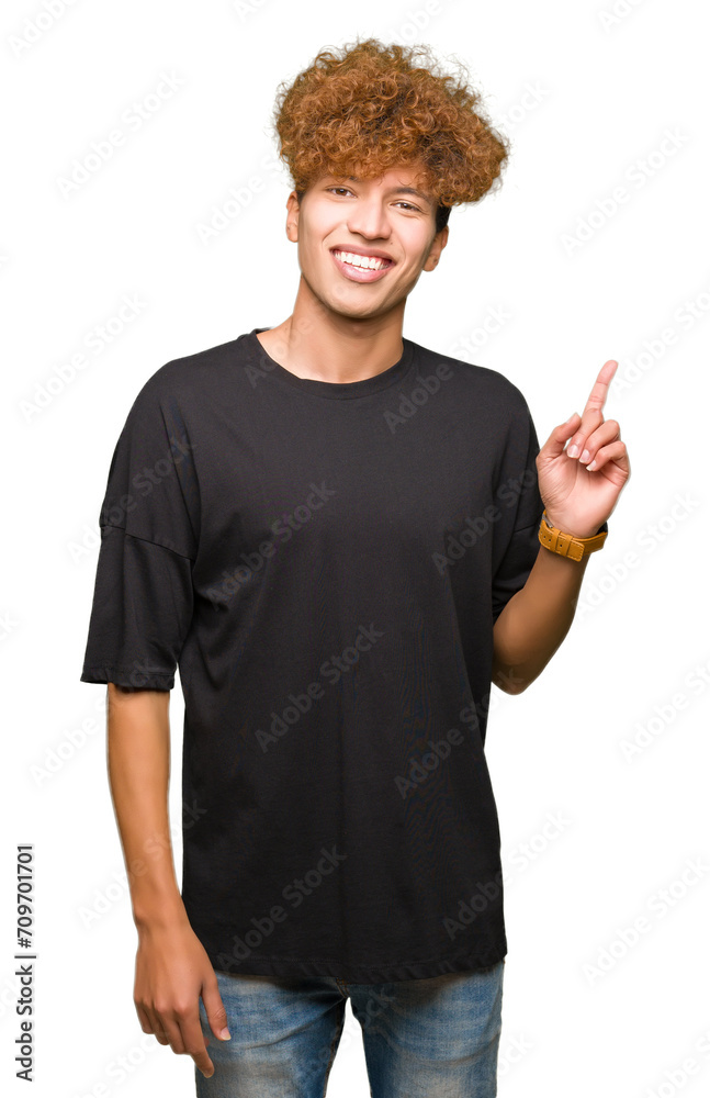 Young handsome man with afro hair wearing black t-shirt with a big smile on face, pointing with hand and finger to the side looking at the camera. Young handsome man with afro hair wearing black t-shirt with a big smile on face, pointing with hand and finger to the side looking at the camera.
