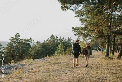 A couple in love holding hands while hiking in the mountains. Rear view. © dsheremeta