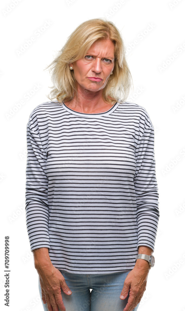 Middle age blonde woman over isolated background skeptic and nervous, frowning upset because of problem. Negative person.