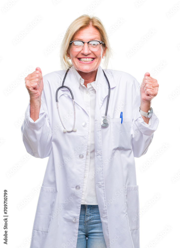 Middle age blonde doctor woman over isolated background excited for success with arms raised celebrating victory smiling. Winner concept. Middle age blonde doctor woman over isolated background excited for success with arms raised celebrating victory smiling. Winner concept.
