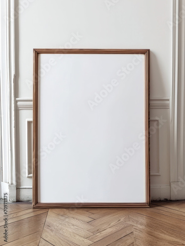 blank vertical wood poster frame standing on light wooden floor against white wall, empty picture frame mockup, blank wooden photo frame mock up