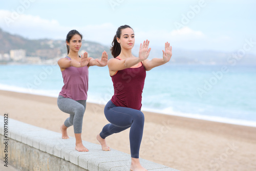 Two women practicing tai chi on the beach
