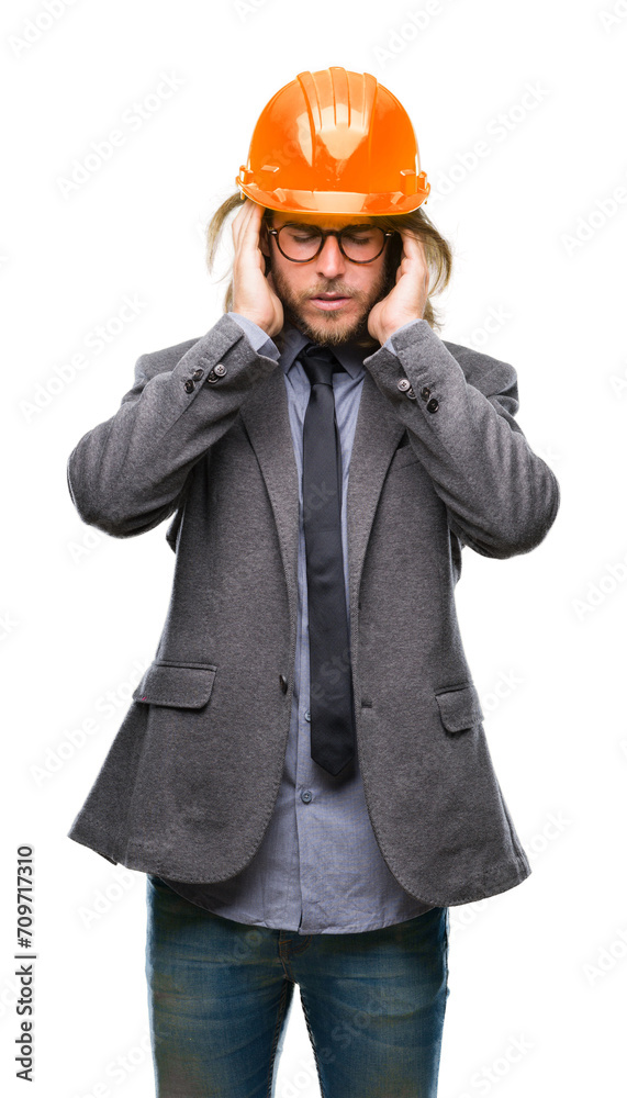 Young handsome architec man with long hair wearing safety helmet over isolated background with hand on head for pain in head because stress. Suffering migraine. Young handsome architec man with long hair wearing safety helmet over isolated background with hand on head for pain in head because stress. Suffering migraine.