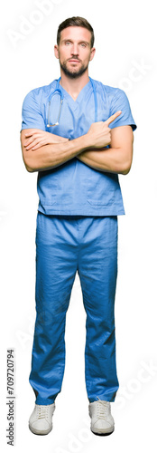 Handsome doctor man wearing medical uniform over isolated background Pointing with hand finger to the side showing advertisement, serious and calm face