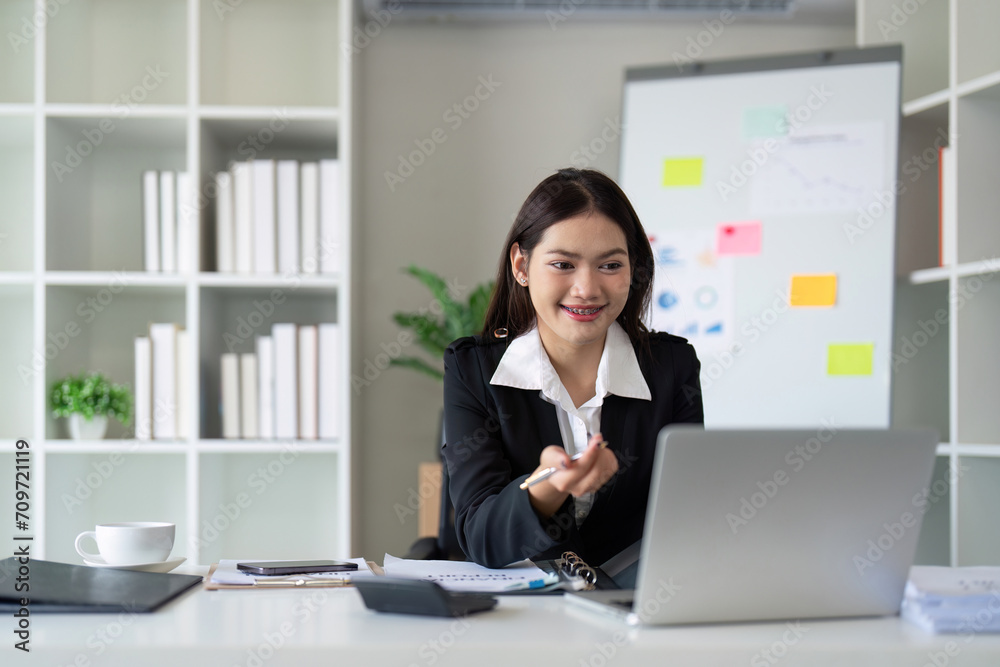 Beautiful asian businesswoman woman using calculator and laptop for doing finance on an office desk, tax, report, accounting, statistics, and analysis research concept Beautiful asian businesswoman woman using calculator and laptop for doing finance on an office desk, tax, report, accounting, statistics, and analysis research concept