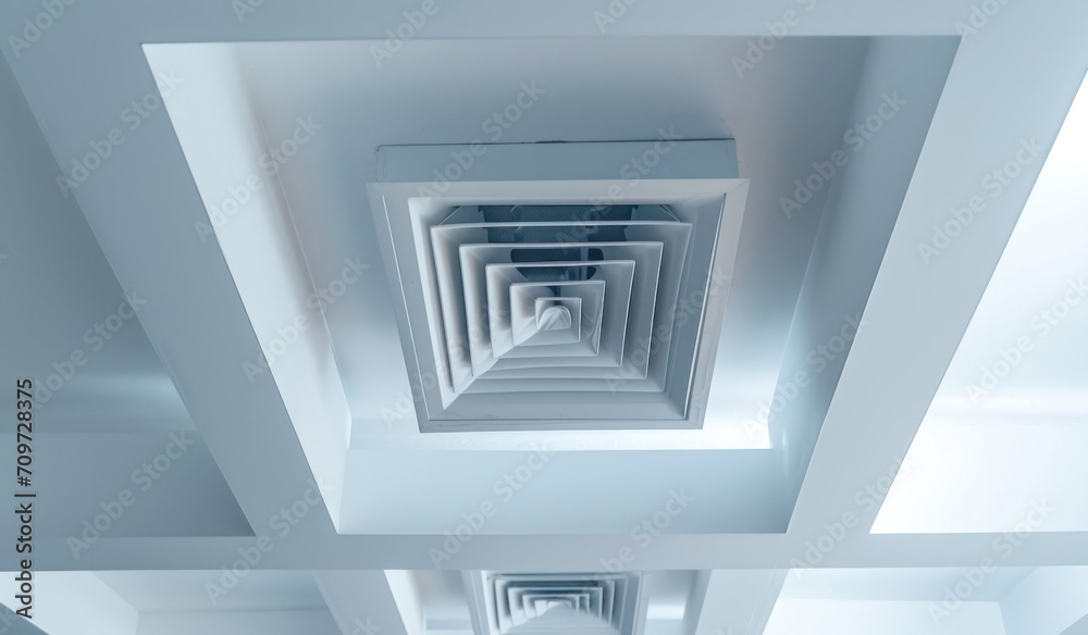 Obraz premium Ceiling mounted cassette type air conditioner and modern lamp light on white ceiling. duct air conditioner for home or office.