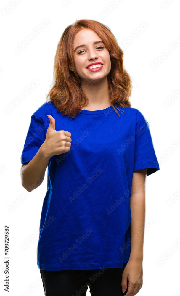 Young beautiful woman over isolated background doing happy thumbs up gesture with hand. Approving expression looking at the camera with showing success.