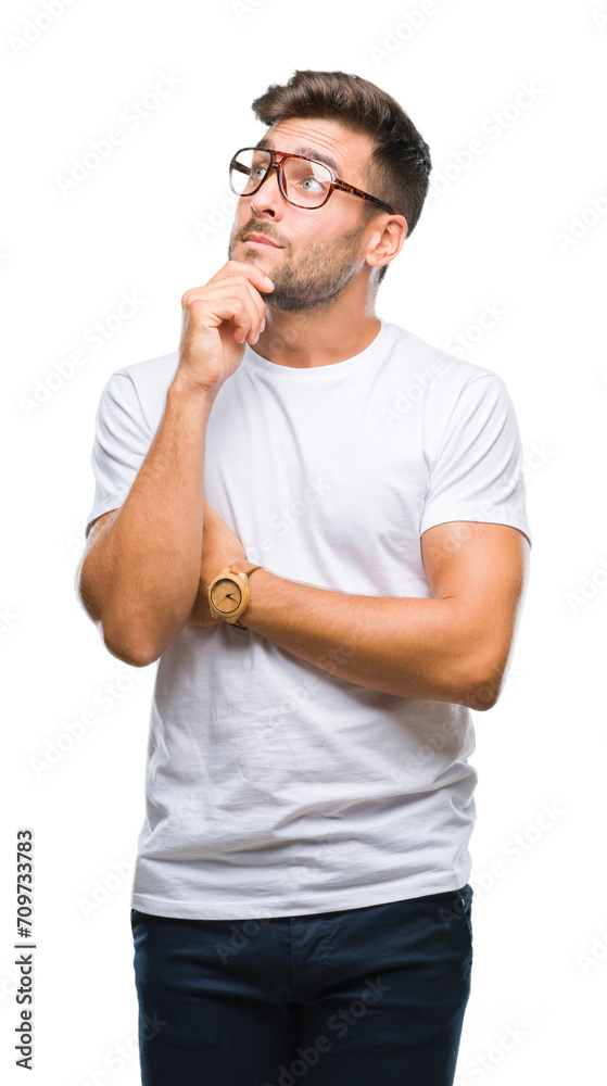 Young handsome man wearing glasses over isolated background with hand on chin thinking about question, pensive expression. Smiling with thoughtful face. Doubt concept. Young handsome man wearing glasses over isolated background with hand on chin thinking about question, pensive expression. Smiling with thoughtful face. Doubt concept.