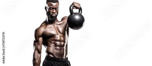 Black young fit muscular man training with kettlebell isolated on white background. Strength and motivation, sport concept.